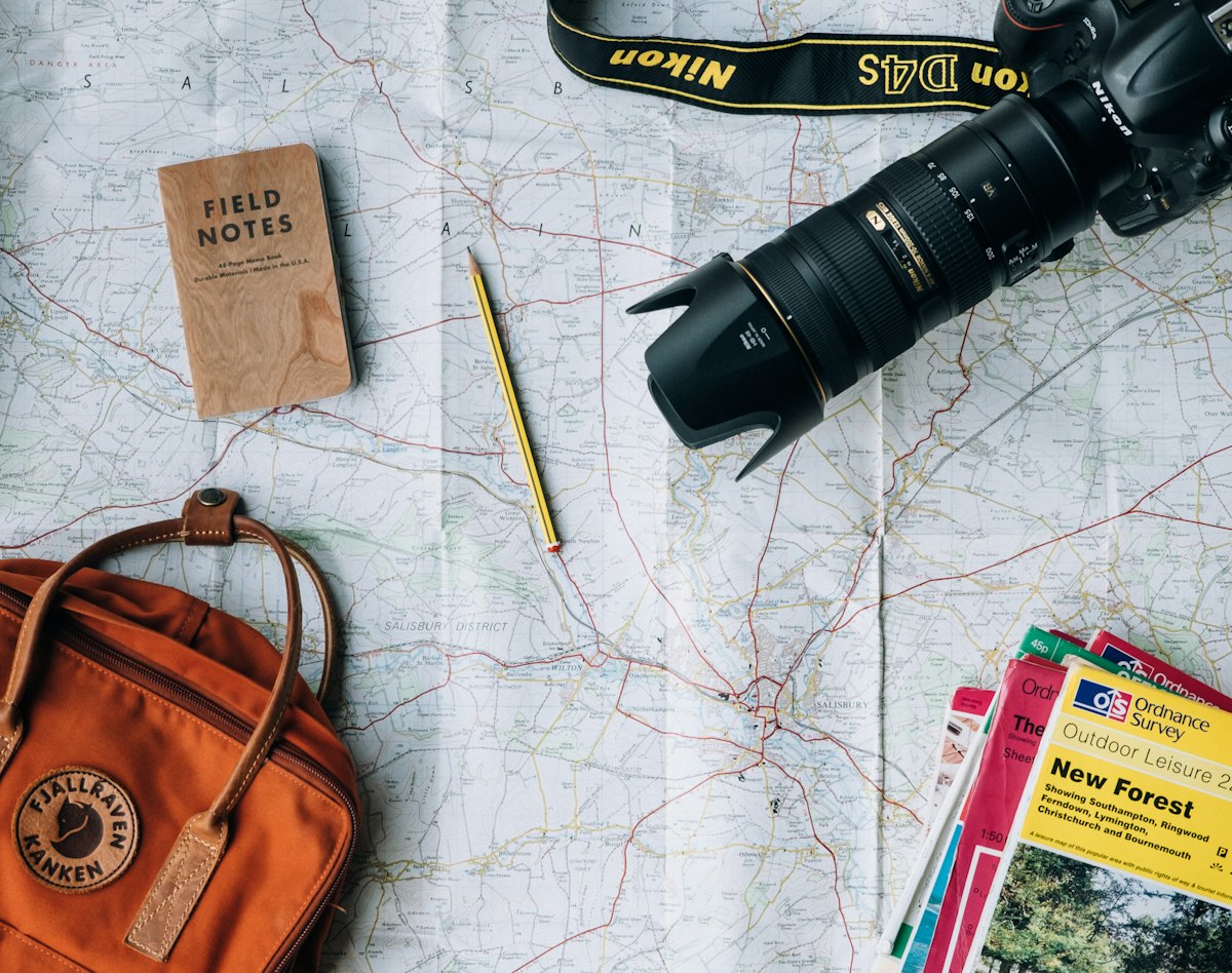 Travel map, notebook and camera laid out while planning a trip
