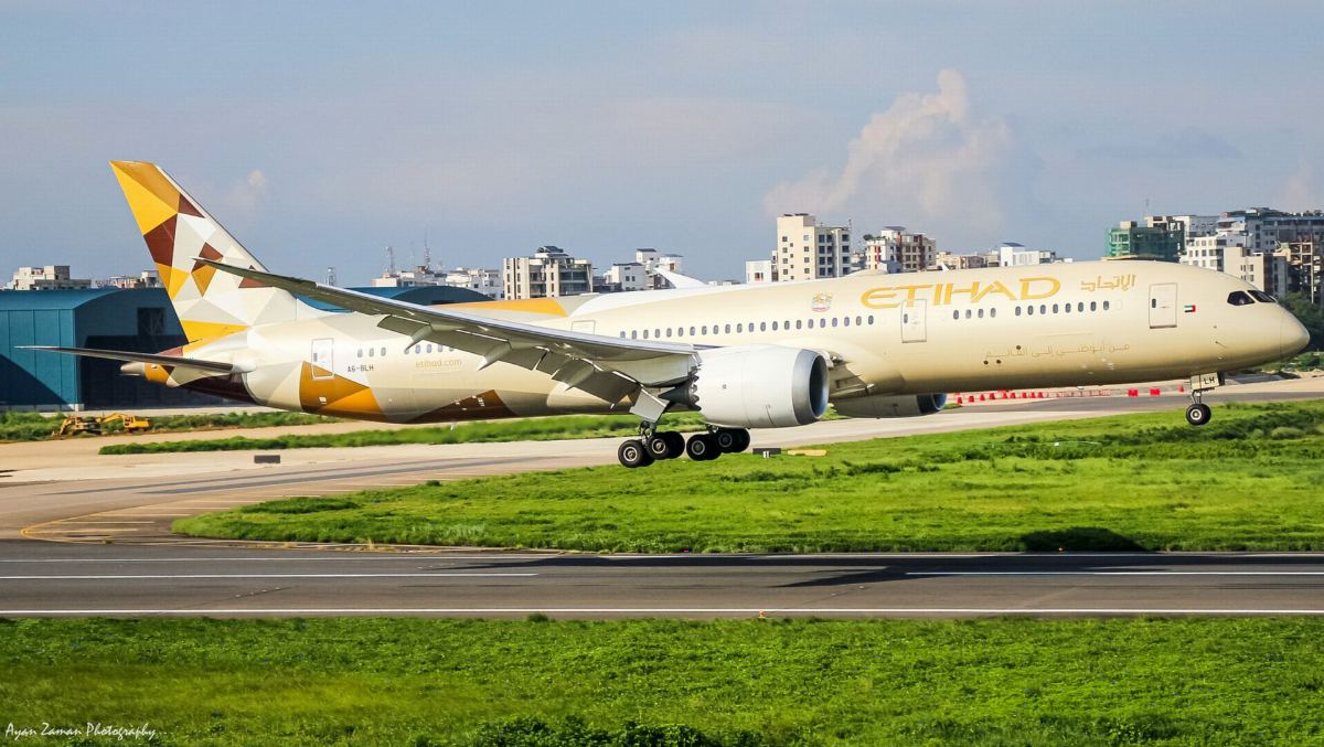 Etihad Airways Boeing 787-9 Dreamliner landing with city buildings behind
